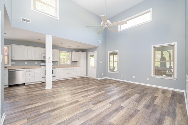 2902 Brughs Mill Rd, Fincastle, VA 24090 - unfurnished living room featuring decorative columns, light wood-style floors, visible vents, a ceiling fan, and a high ceiling