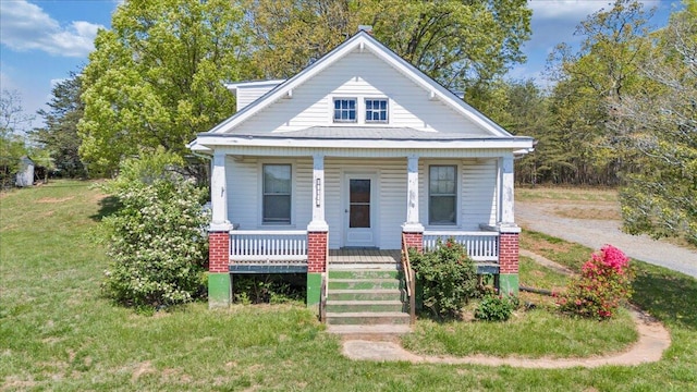 bungalow with a porch and a front lawn