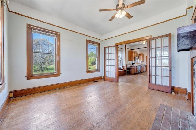 empty room featuring visible vents, french doors, wood-type flooring, baseboards, and ceiling fan