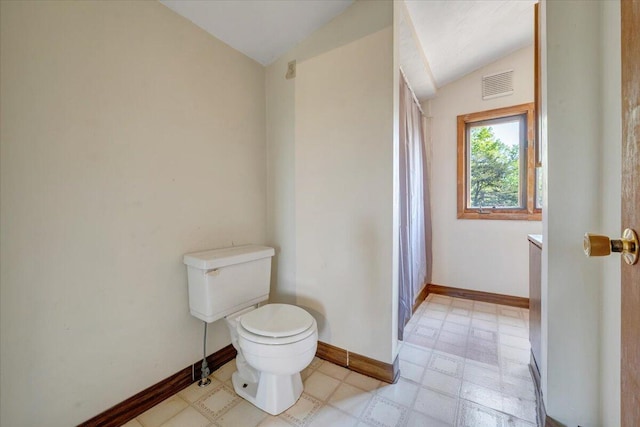 bathroom featuring toilet, tile patterned floors, baseboards, lofted ceiling, and visible vents
