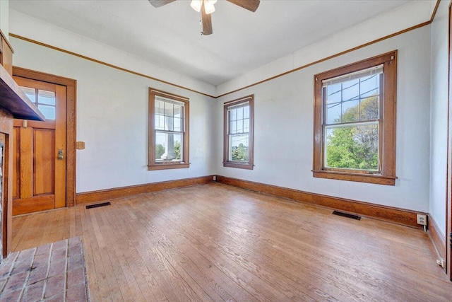 unfurnished room with baseboards, visible vents, ceiling fan, and wood-type flooring