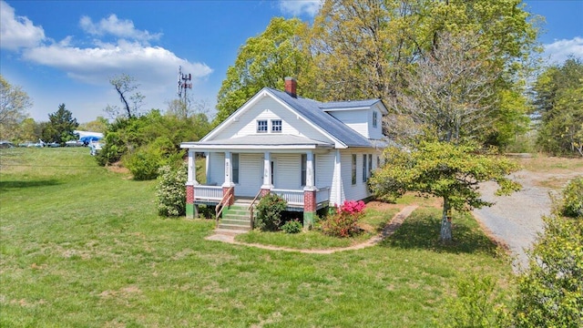 bungalow-style home featuring a porch, a front lawn, and a chimney