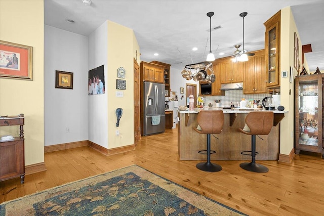 30 Boulder Point Dr, Hardy, VA 24101 - kitchen with stainless steel fridge with ice dispenser, brown cabinets, a peninsula, light wood-style flooring, and under cabinet range hood