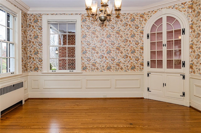 2912 Wycliffe Ave SW, Roanoke, VA 24014 - unfurnished dining area with a wainscoted wall, a notable chandelier, radiator heating unit, wallpapered walls, and wood finished floors