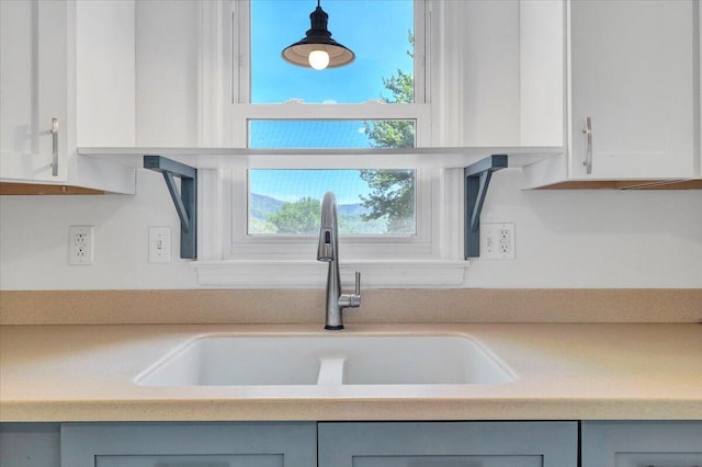 details with gray cabinets, light countertops, and a sink
