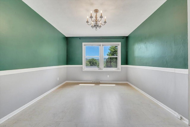 spare room with baseboards, visible vents, and an inviting chandelier