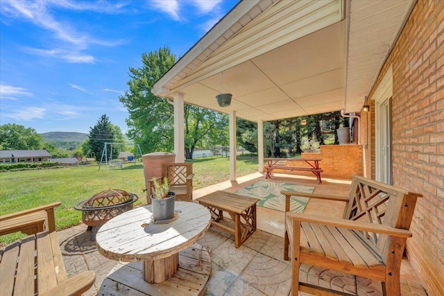 view of patio with an outdoor fire pit and a mountain view