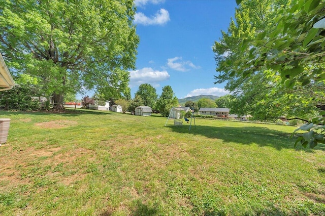 view of yard featuring a storage unit, a mountain view, and an outdoor structure