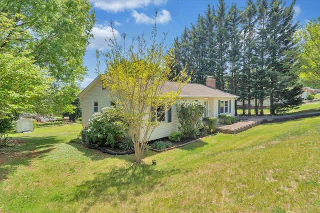 view of home's exterior featuring a chimney, a storage unit, an outdoor structure, and a lawn