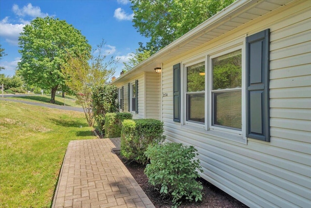 view of side of home with a lawn
