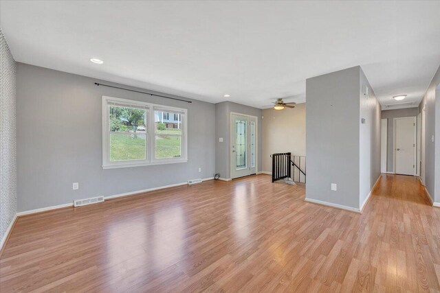 unfurnished living room with visible vents, light wood-style flooring, and baseboards