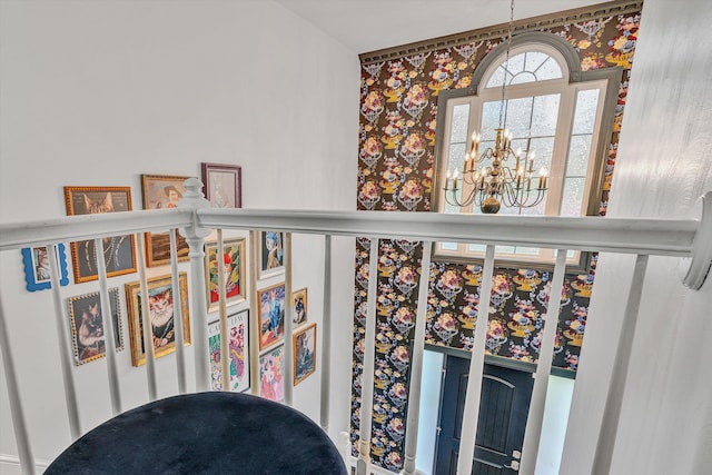 interior details featuring a chandelier and wallpapered walls