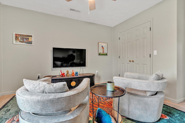 living room with baseboards, visible vents, a ceiling fan, and carpet flooring