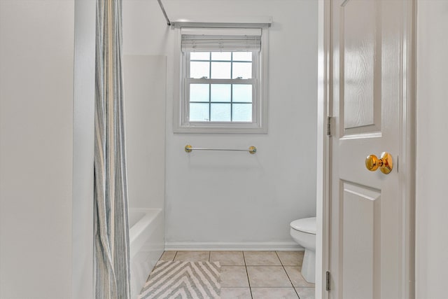 bathroom with tile patterned floors, baseboards, shower / bath combo with shower curtain, and toilet