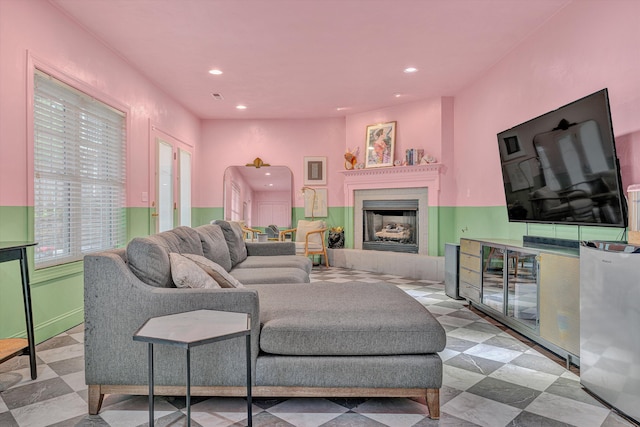 living area with recessed lighting and a fireplace with raised hearth
