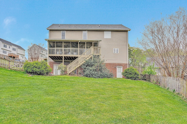 back of property with a lawn, fence, a sunroom, and stairs