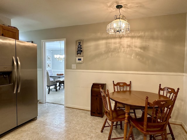 dining space featuring a chandelier and wainscoting