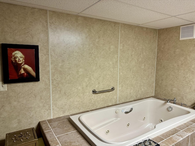 full bathroom with a paneled ceiling, visible vents, and a jetted tub