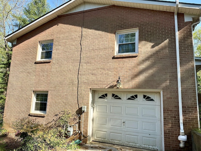 view of side of property with brick siding and an attached garage