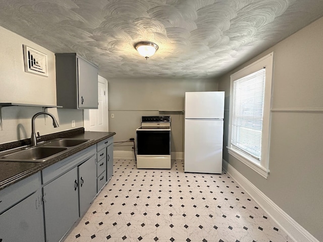 1414 Wise Ave SE, Roanoke, VA 24013 - kitchen with freestanding refrigerator, range, a sink, dark countertops, and light flooring
