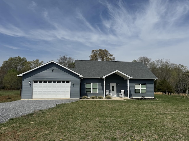 single story home featuring gravel driveway, an attached garage, and a front yard
