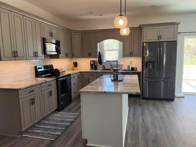 kitchen with appliances with stainless steel finishes, gray cabinetry, and a healthy amount of sunlight