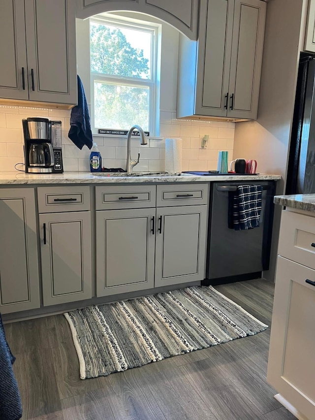 kitchen featuring dishwasher, wood finished floors, a sink, and gray cabinets