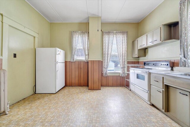 kitchen with white appliances, open shelves, wooden walls, light countertops, and wainscoting