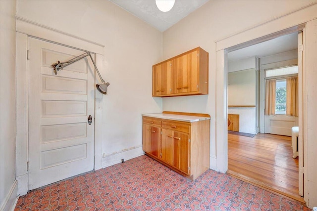 washroom with light floors, radiator heating unit, and baseboards