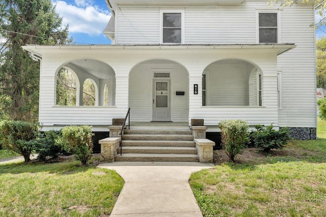 view of front of home featuring covered porch and a front lawn