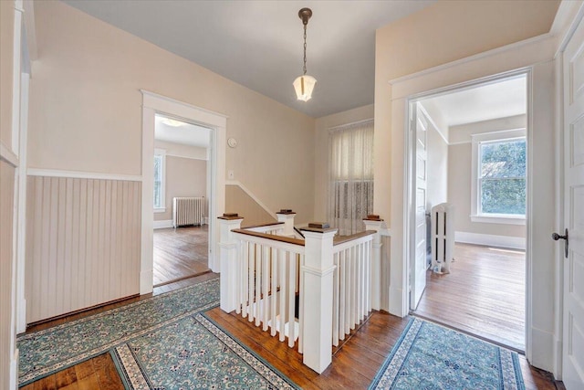 hallway with radiator, an upstairs landing, and wood finished floors