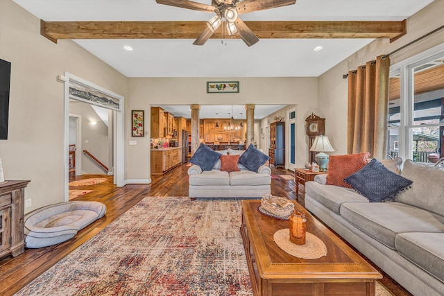 living area featuring dark wood finished floors, beam ceiling, baseboards, decorative columns, and ceiling fan