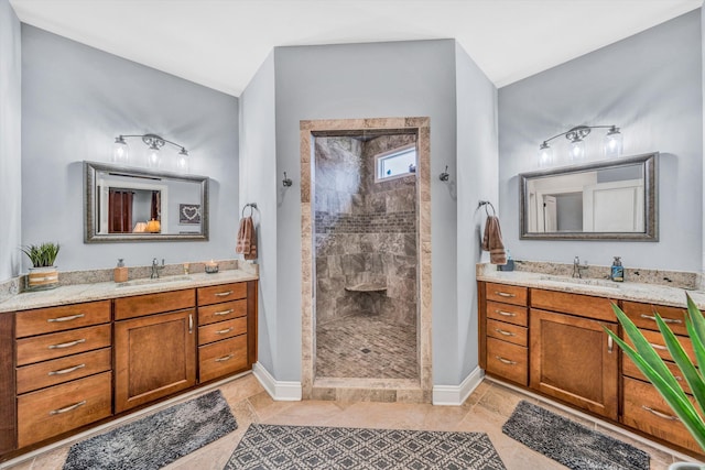 bathroom with two vanities, a sink, a walk in shower, and baseboards