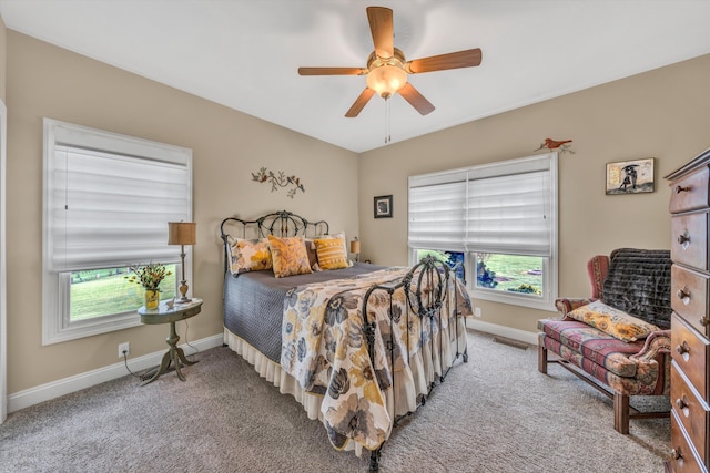 bedroom with baseboards, visible vents, light colored carpet, and multiple windows