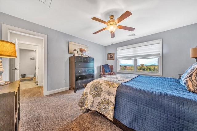 bedroom featuring baseboards, visible vents, light colored carpet, and ceiling fan