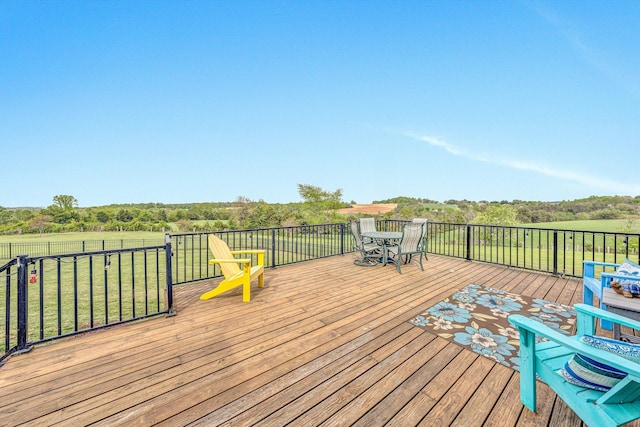 deck with outdoor dining space and a lawn
