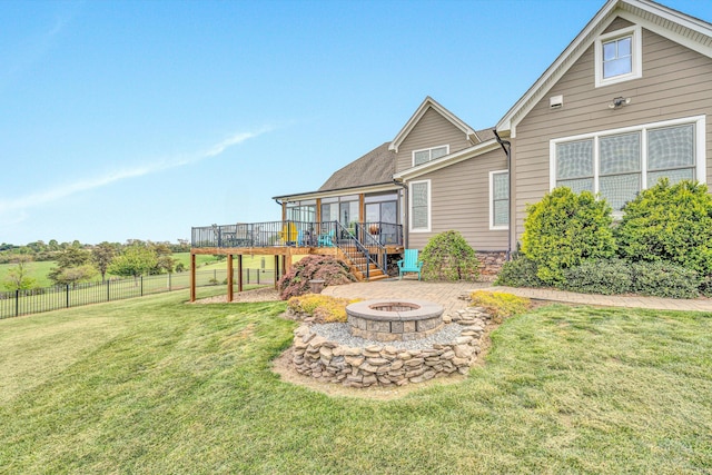 rear view of property featuring fence, stairway, a deck, a yard, and an outdoor fire pit