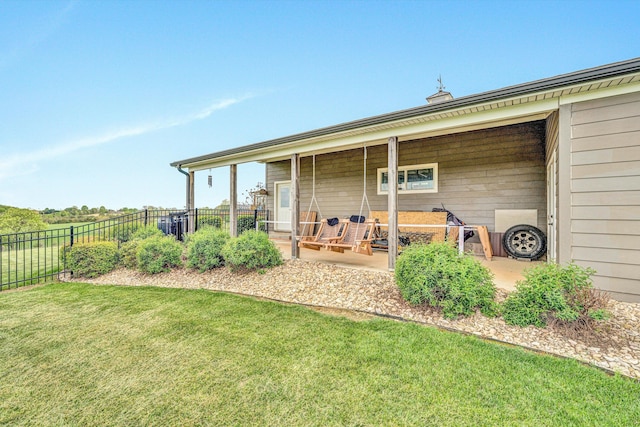 rear view of house featuring a yard and fence