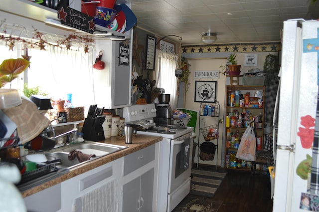 kitchen with white cabinets, a sink, and white appliances