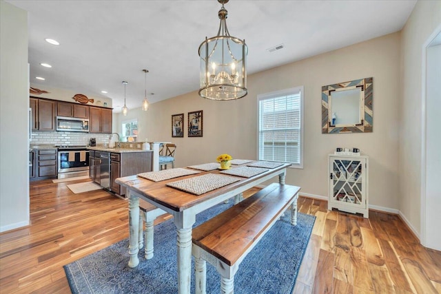dining area with recessed lighting, light wood-style floors, baseboards, and a chandelier