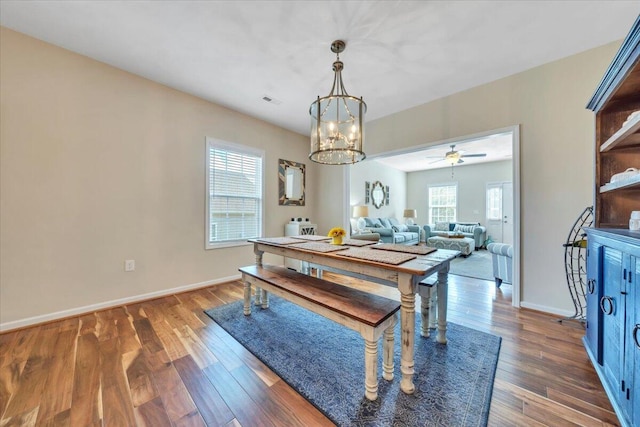 dining space with healthy amount of natural light, a chandelier, and wood finished floors