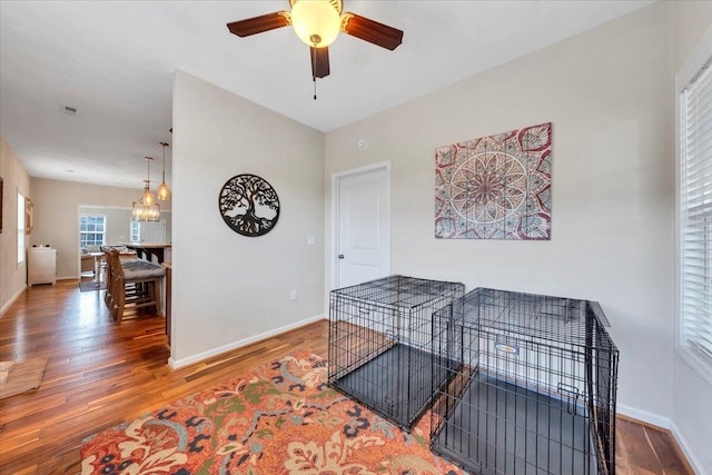 hall featuring a chandelier, wood finished floors, and baseboards