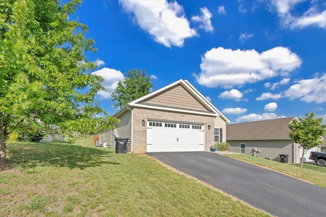 view of front of house featuring brick siding, a front lawn, and asphalt driveway