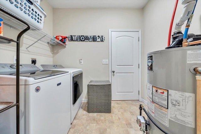 clothes washing area featuring gas water heater and separate washer and dryer