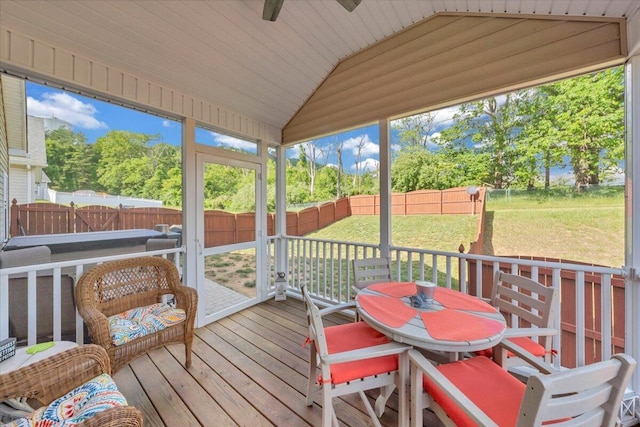 sunroom / solarium featuring a ceiling fan, vaulted ceiling, and outdoor dining area