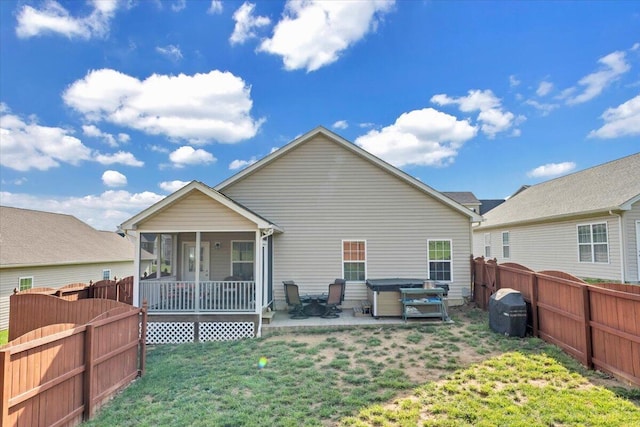rear view of house featuring a hot tub, a patio area, and a sunroom