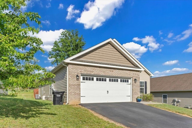 view of side of home with brick siding, a yard, cooling unit, and asphalt driveway