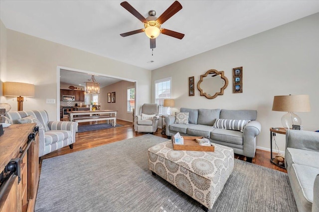 living room featuring a chandelier, wood finished floors, ceiling fan, and baseboards