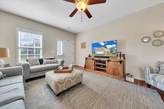 living area with ceiling fan, baseboards, and wood finished floors
