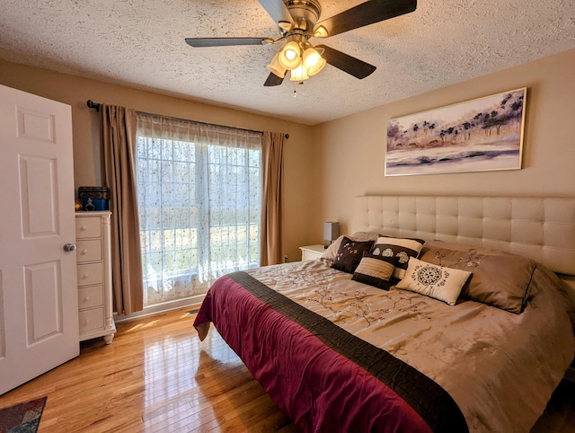 bedroom with light wood finished floors, a textured ceiling, and ceiling fan
